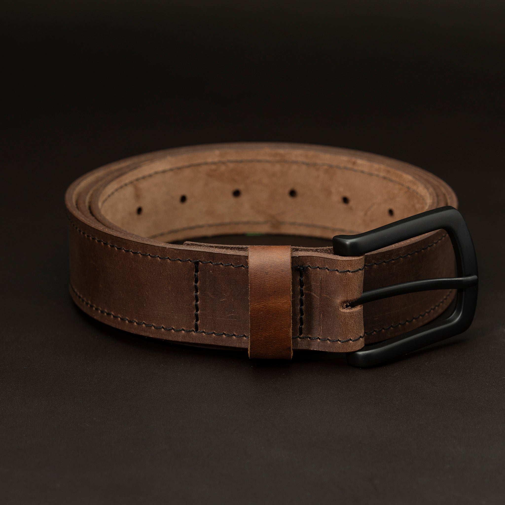 Dark brown leather belt with black buckle and dark stitching