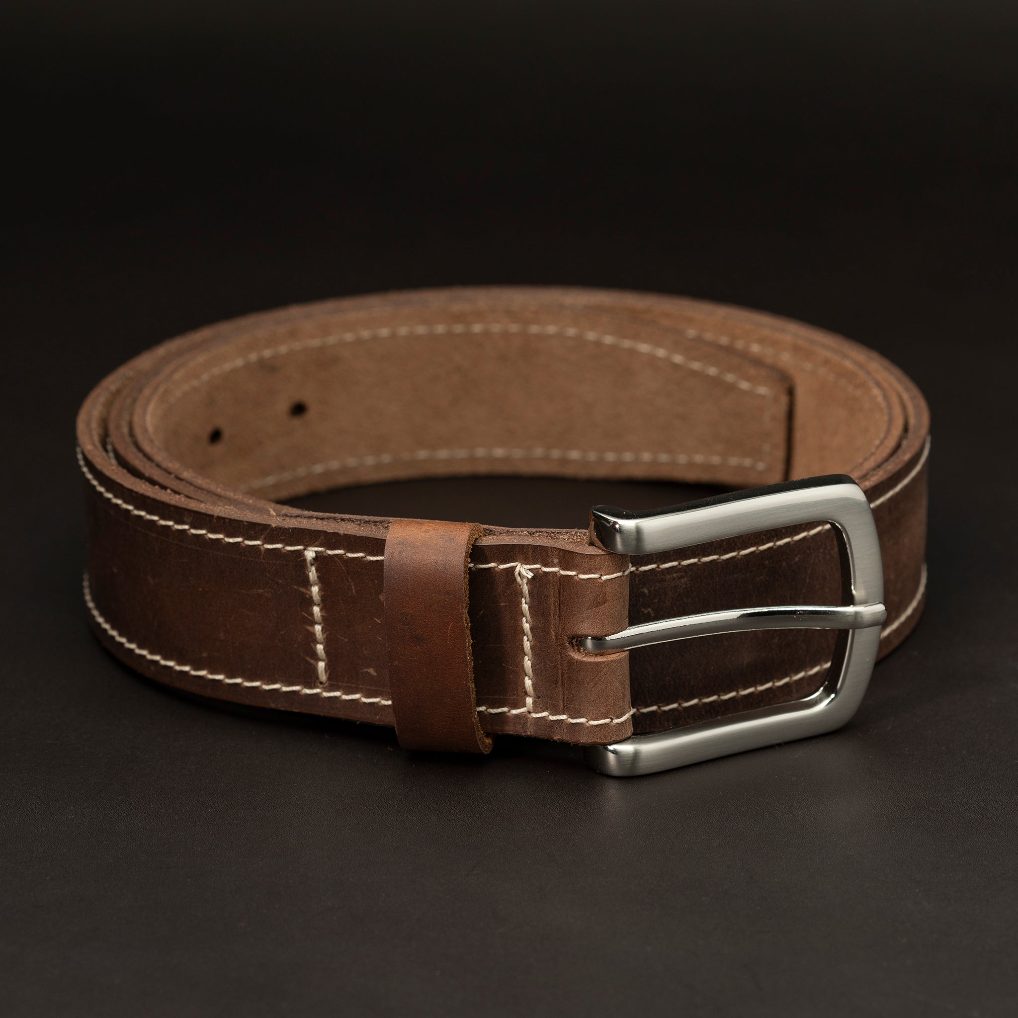 Dark brown leather belt with silver buckle and white stitching