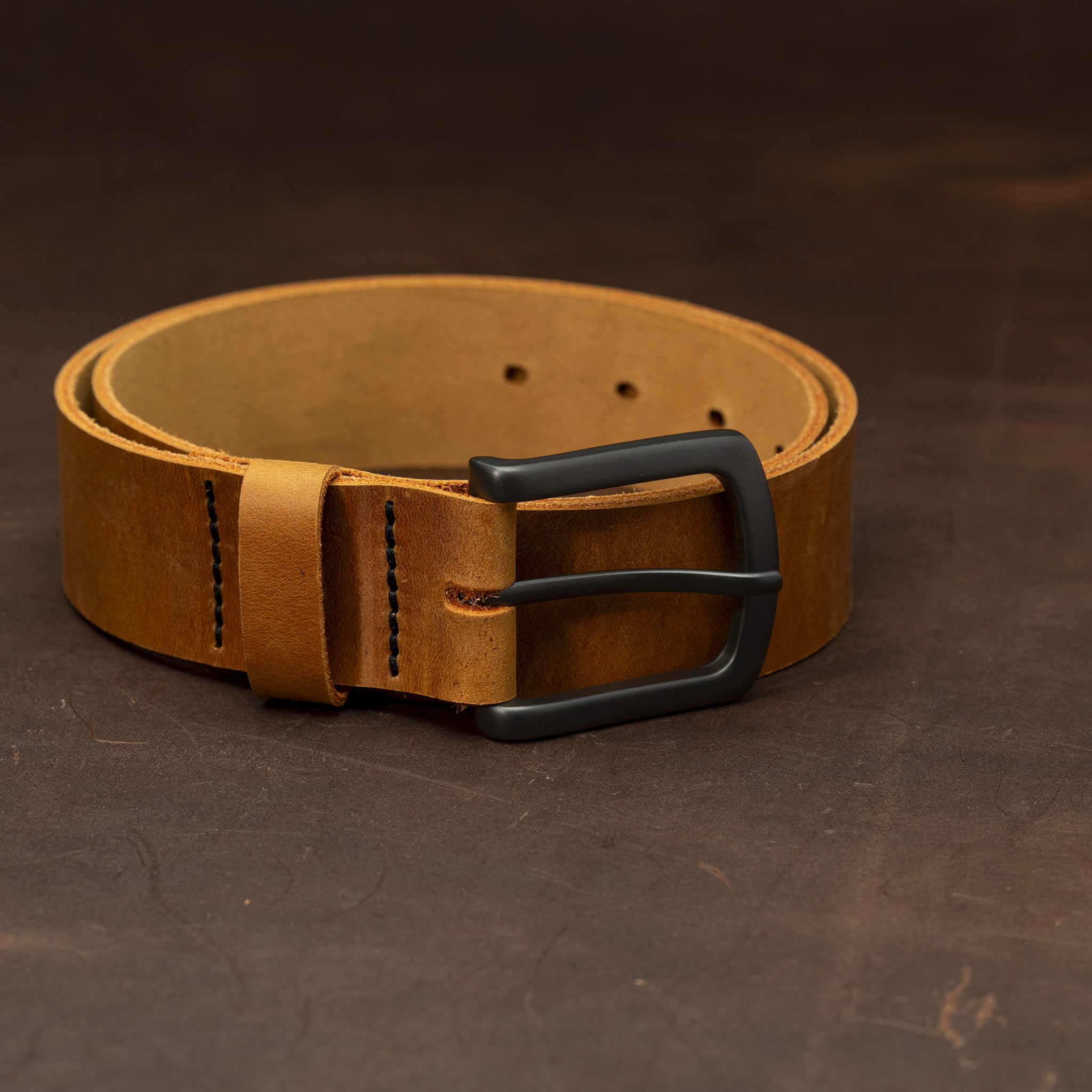 Light brown leather belt with black buckle