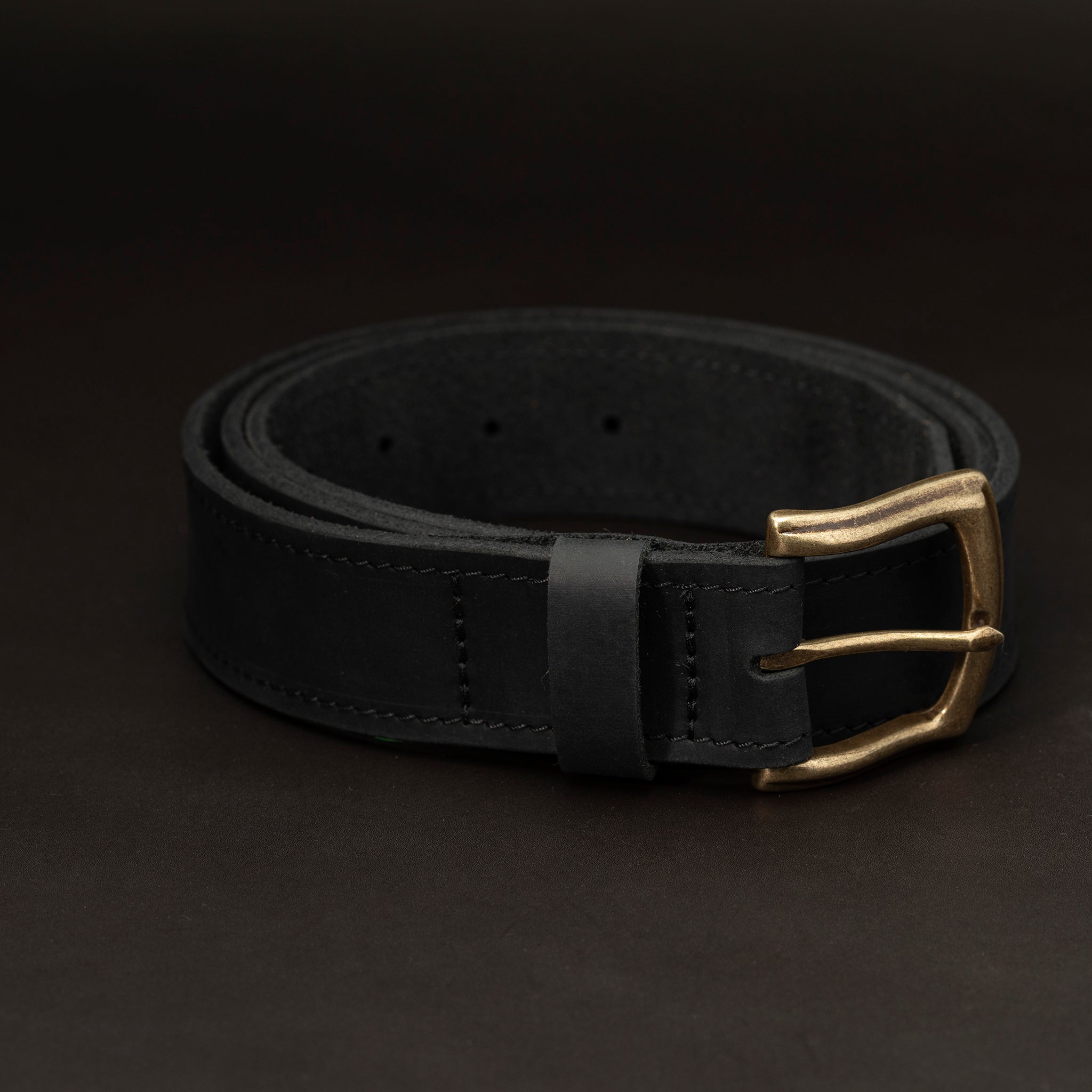 Black leather belt with brass buckle and dark stitching